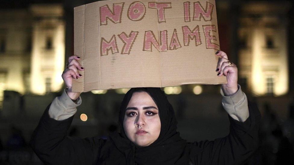 Muslim woman with "not in my name" placard at vigil, Trafalgar Square.