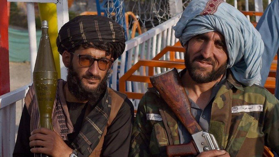 Taliban fighters pose with weapons at a fairground on 28 September, 2021