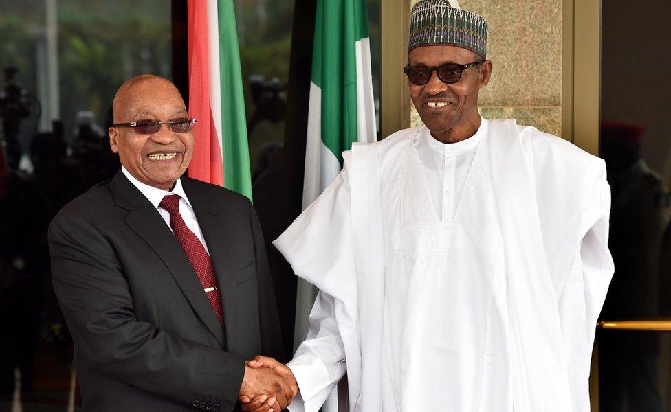 South African President Jacob Zuma (L) being welcomed by Nigerian President Muhammud Buhari (R) during the official welcome ceremony at the State House in Abuja, Nigeria