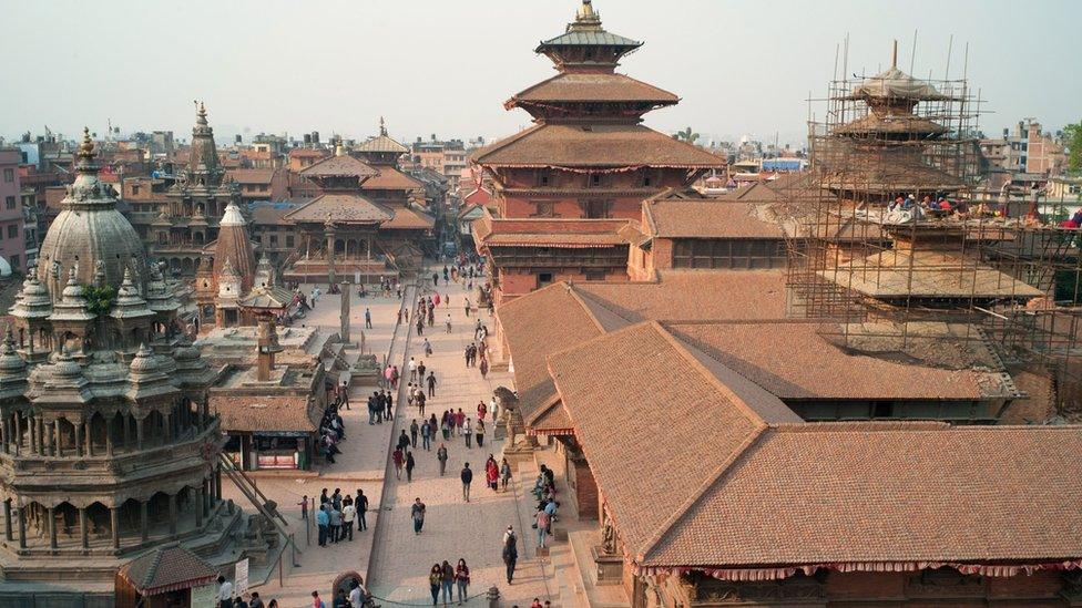 Nepalese workers restore a temple (right) in Durbar Square in Patan, south of Kathmandu, 10 April 2016