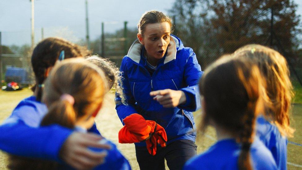 Youth football coach with team