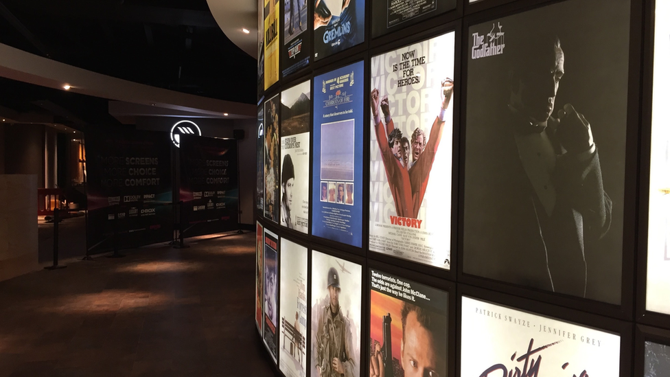 A corridor inside the Empire Cinema in Ipswich with a wall covered in film posters