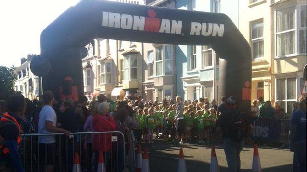 Ironman competitors run in the street