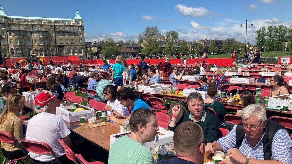 People sitting at long tables in Parker's Piece, Cambridge