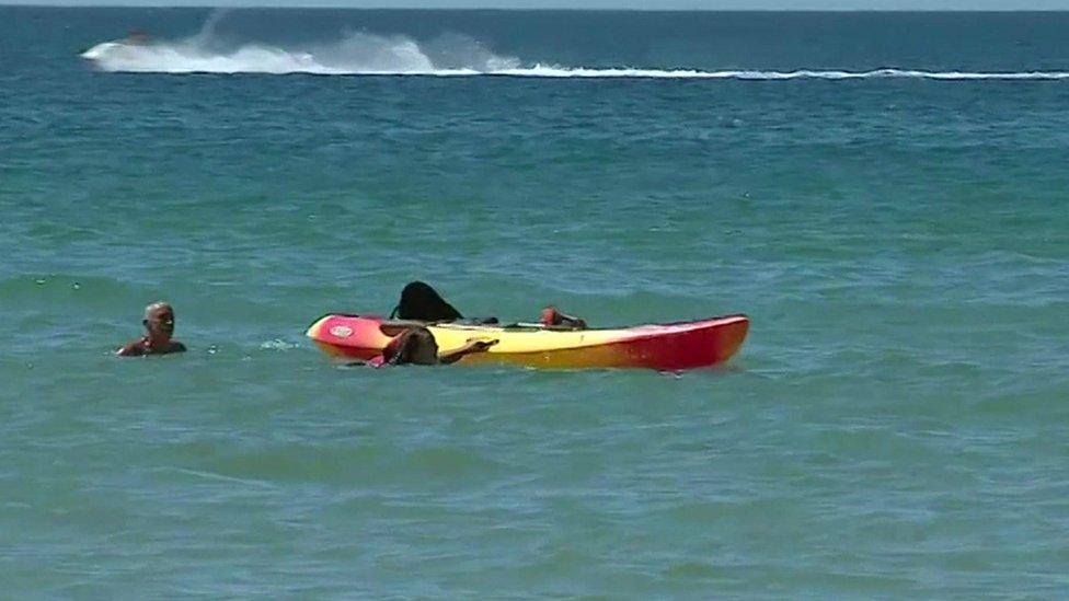 President Marcelo Rebelo de Sousa helps two women in the water