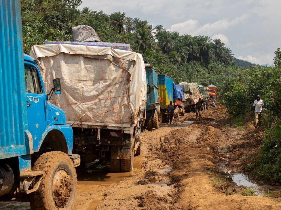 Lorries try to negotiate a muddy country road