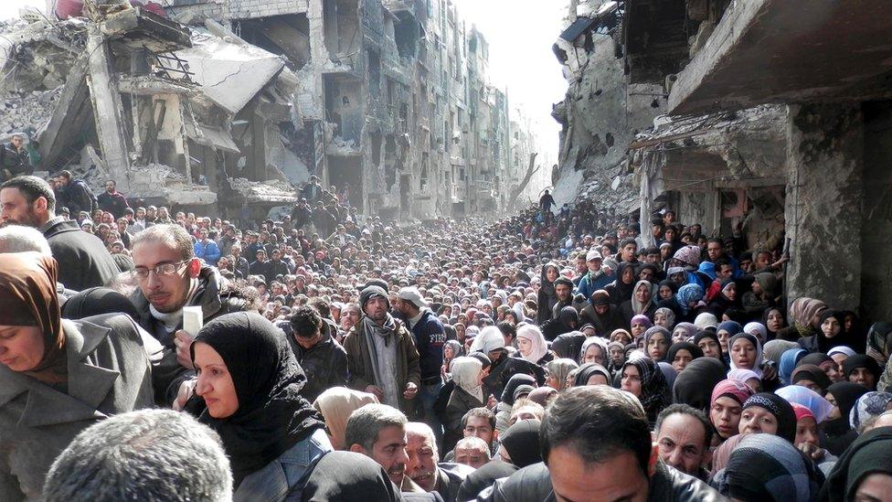 Residents in heavily bombed part of Damascus queue for food (Jan 2014)