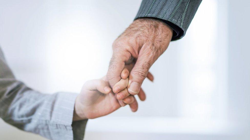 Grandfather holding a child's hand