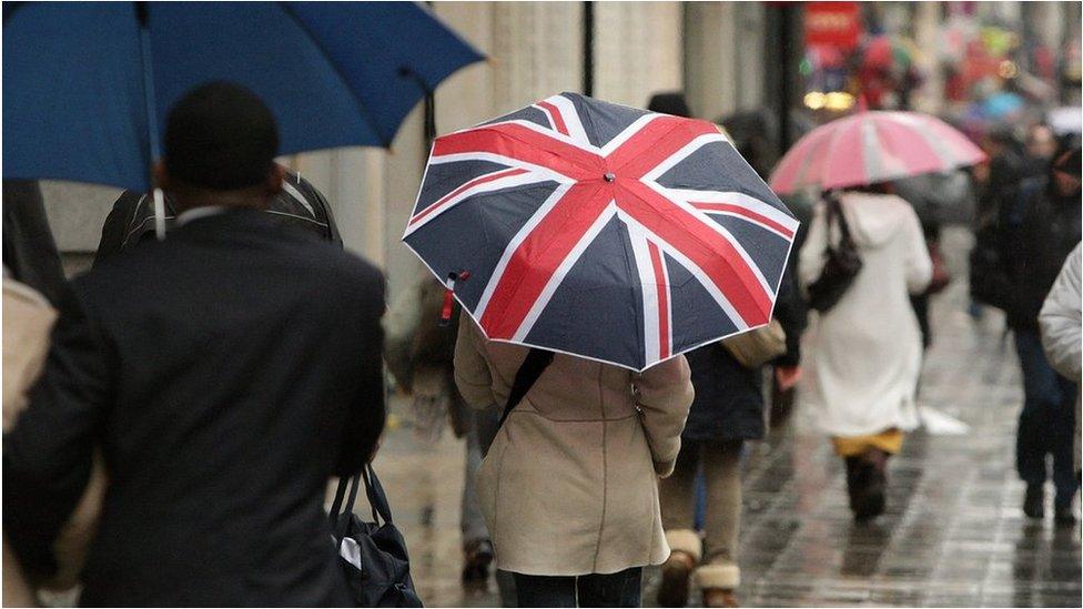 A shopper holds an umbrella decorated with the Union Jack flag