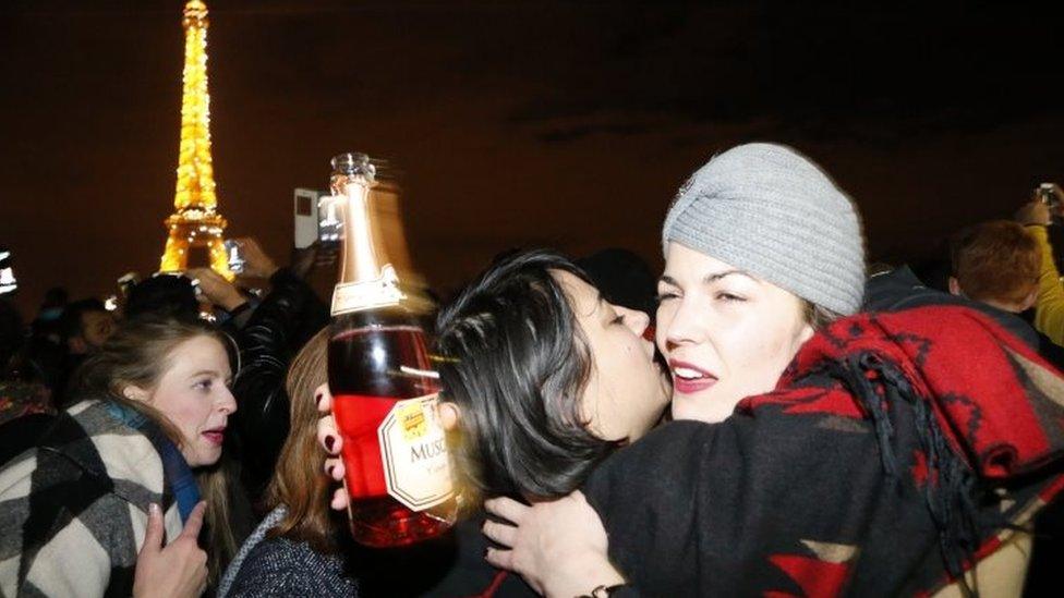 People embrace near the Eiffel tower during New Year celebrations in Paris (01 January 2016)