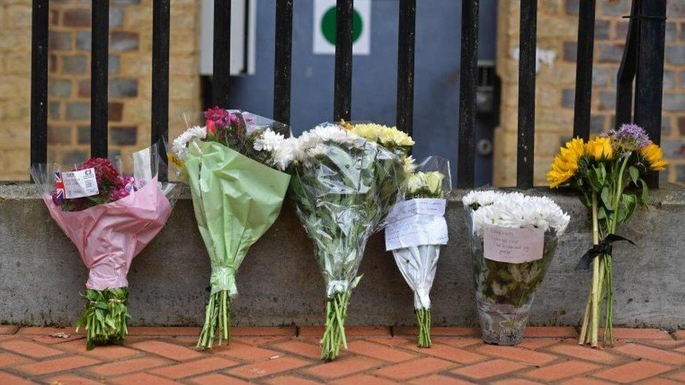 Floral tributes are seen at a police cordon at the Abbey Gateway near Forbury Gardens park in Reading