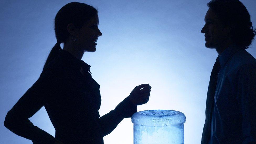 Two people next to water cooler