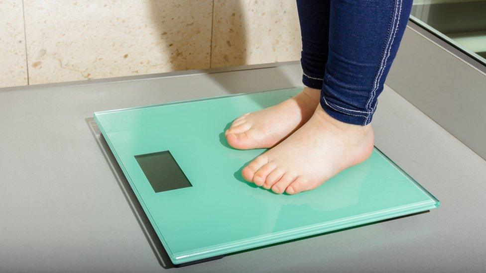 A child stood on weighing scales