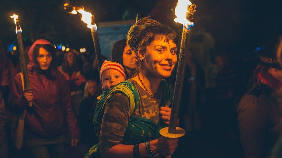 A youngster enjoys the ambience as those in the procession carry torches through Portmeirion Village.