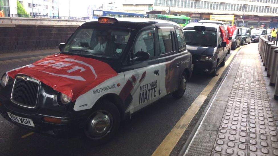 Taxis in Birmingham displaying RMT flags and posters