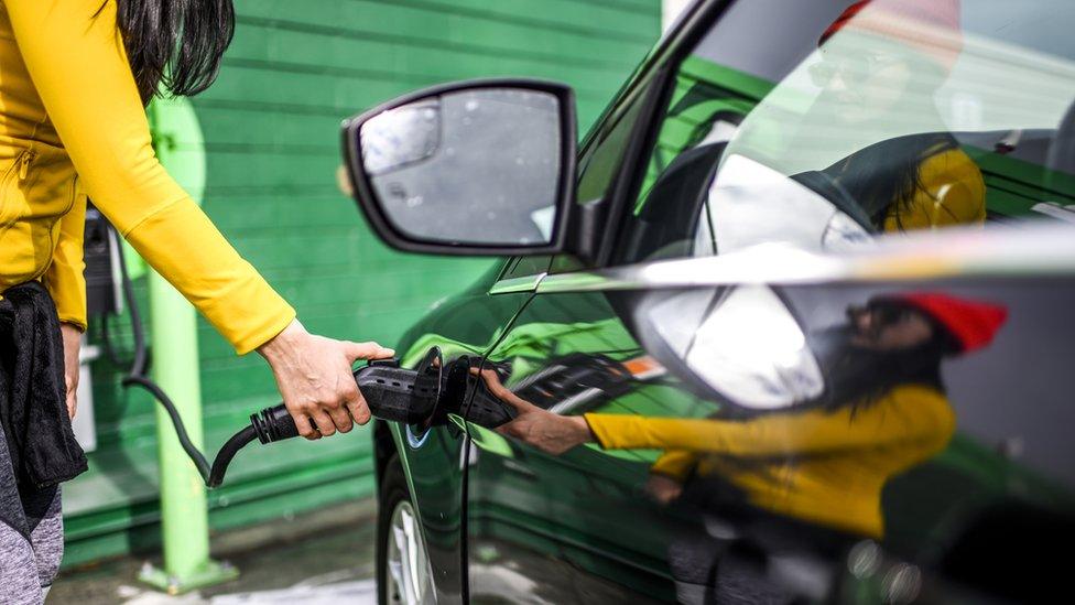 Woman charging electric car