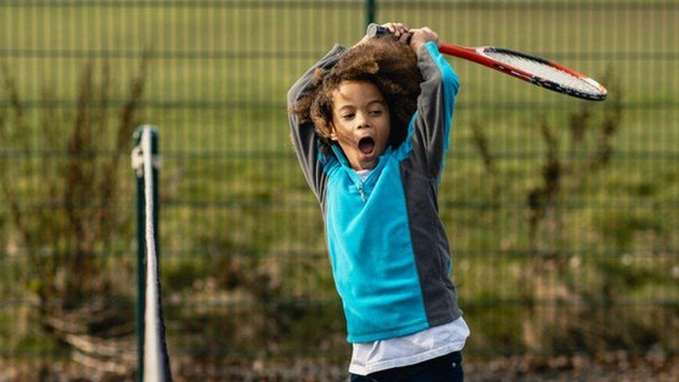 Child playing tennis