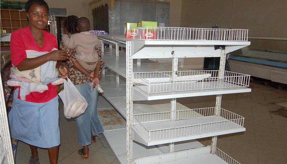 JULY 4th 2007: Zimbabwean shoppers walk past empty shelves in Mabvuku, Harare, Zimbabwe. Zimbabwe's government ordered shop owners to reduce prices on all goods by 50% which has resulted in an acute shortage of most basic commodities. President Robert Mugabe has accused businesses of profiteering and working in cahoots with the country's enemies to incite people to revolt against his government.