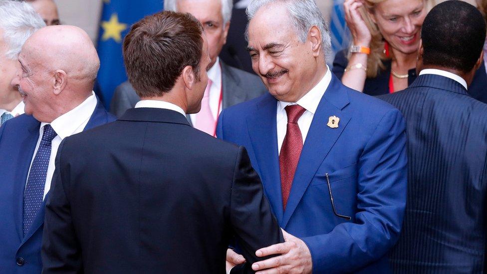 Khalifa Haftar shaking hands with President Macron in Paris