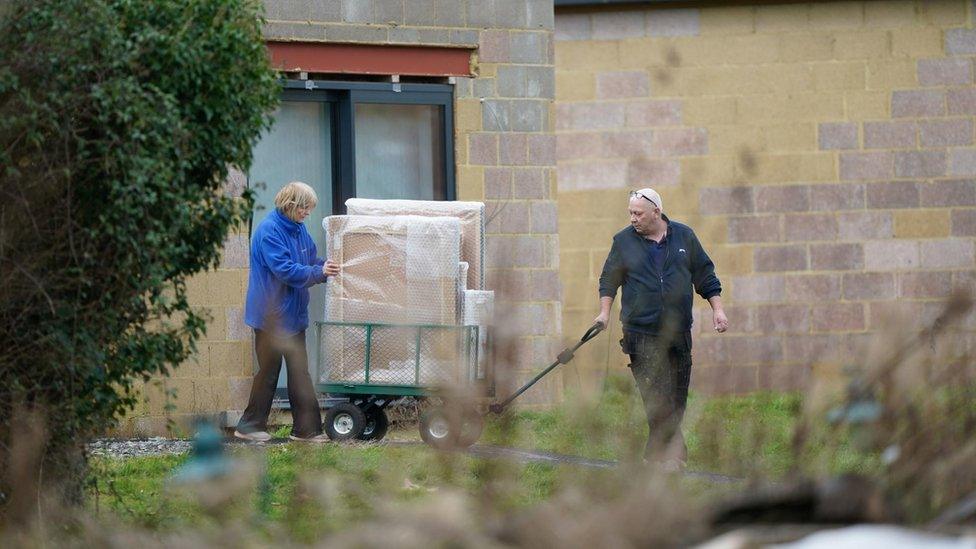 Items being removed from the spa building by workers