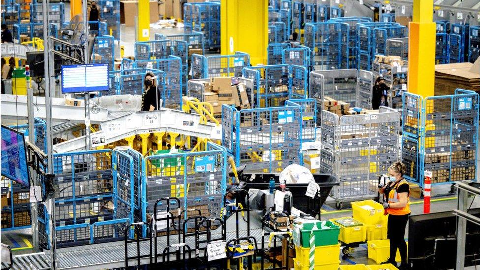 Workers sort out parcels in the outbound dock at Amazon fulfillment center in Eastvale