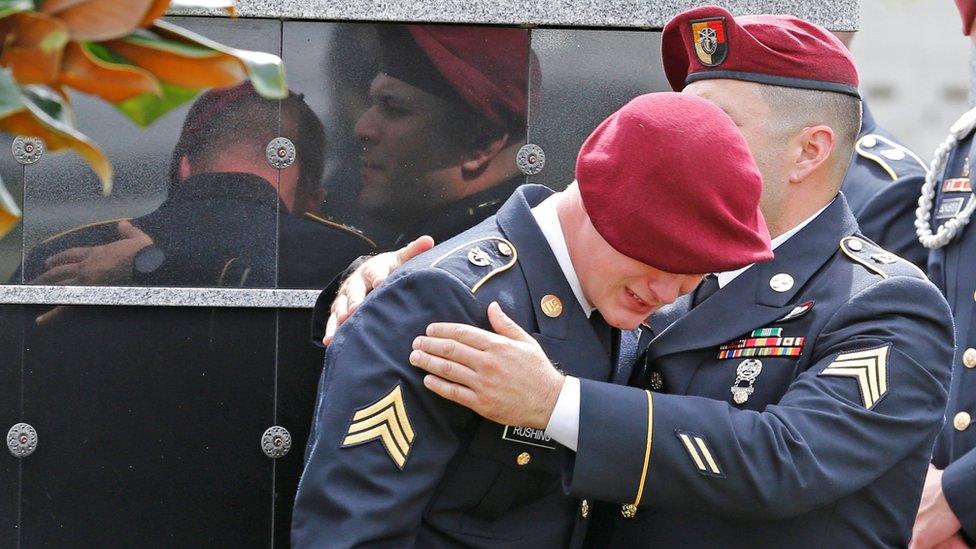 An unidentified honour guard member cries at the graveside service for Sgt La David Johnson