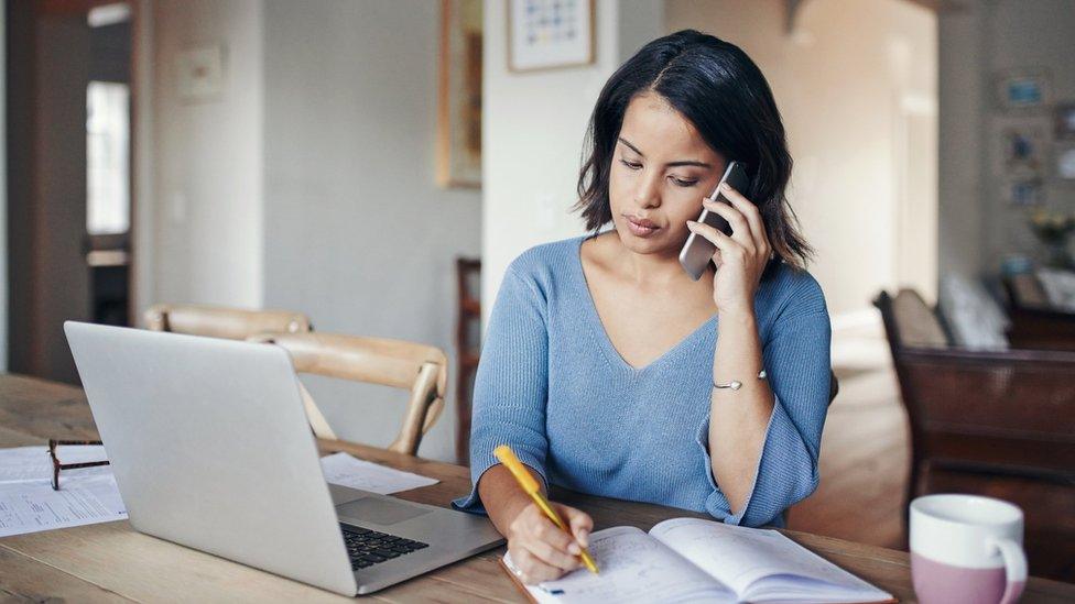 Woman on phone with laptop