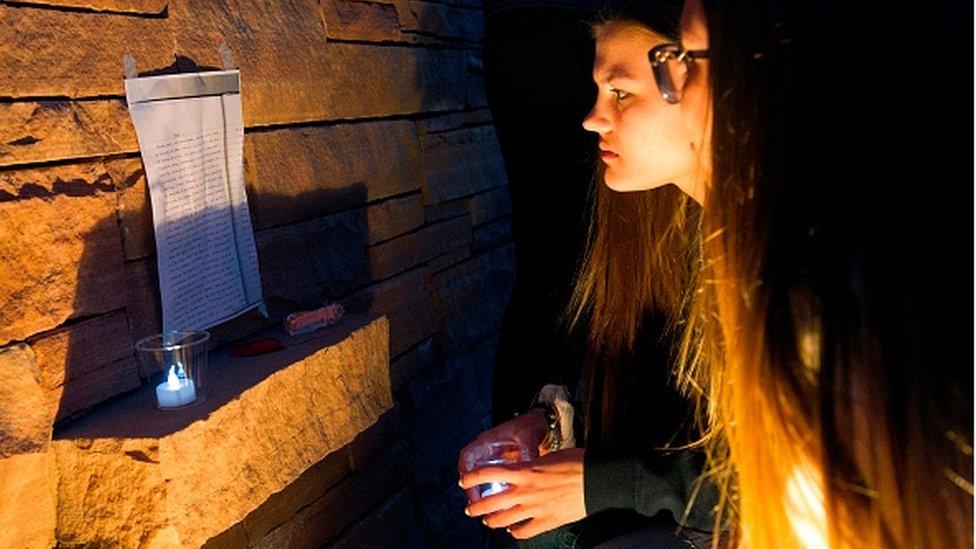 Visitors read a poem left the memorial