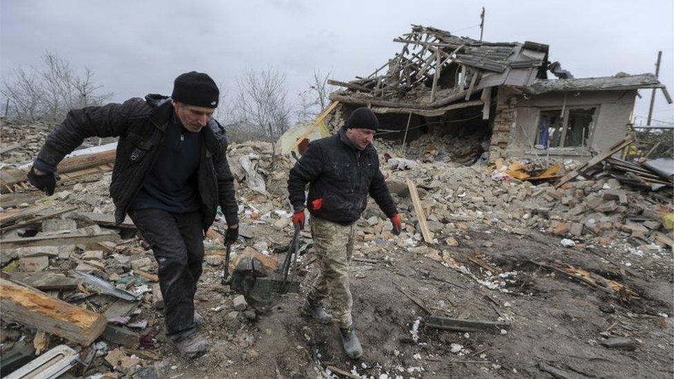 Locals salvage items after two rocket"s hit private buildings in the Zolochiv district near the Western Ukrainian city of Lviv, 09 March 2023. At least five people were killed during the attack