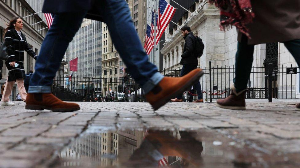 people walking by American flags