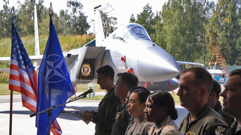 Nato soliders stand in front of US Air Force F-15C Eagle' jet in Lithuania.