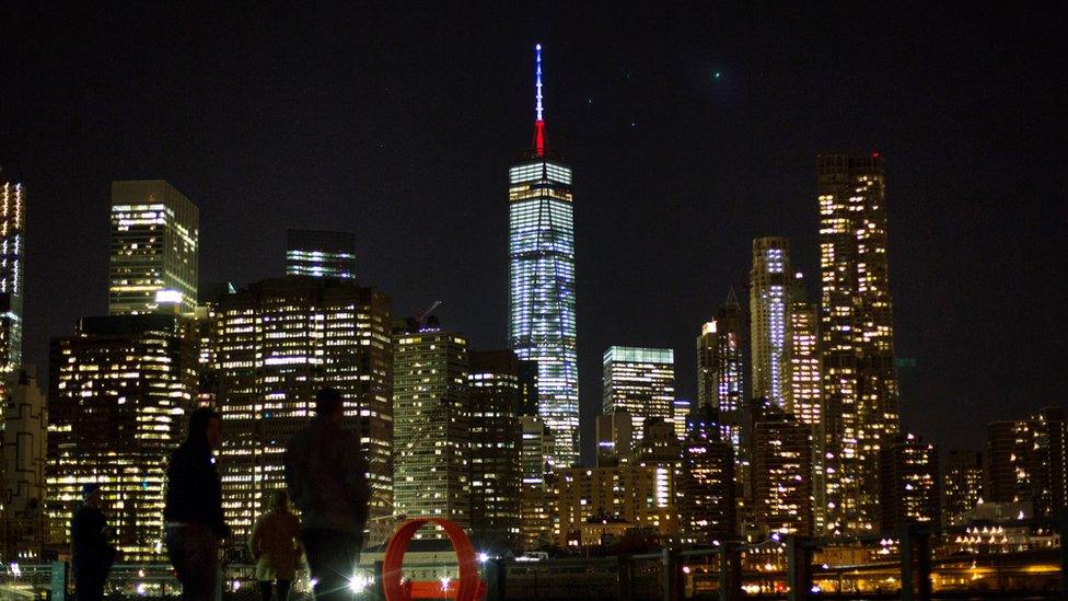 The One World Trade Center spire is lit blue, white and red after New York Gov. Andrew Cuomo announced the lighting in honor of dozens killed in the Paris attacks Friday