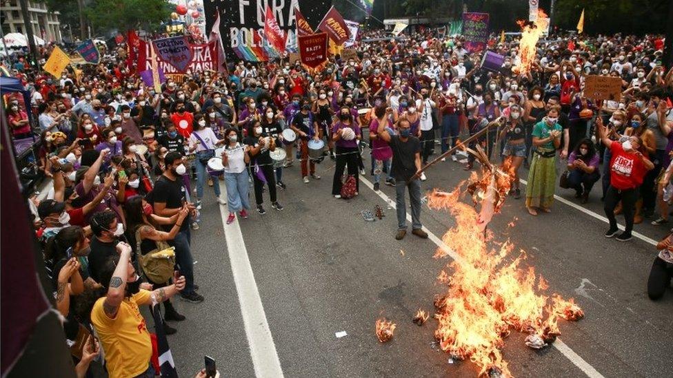 A demonstrator burns a doll representing the president