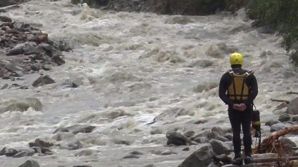 A rescue worker looks at a river