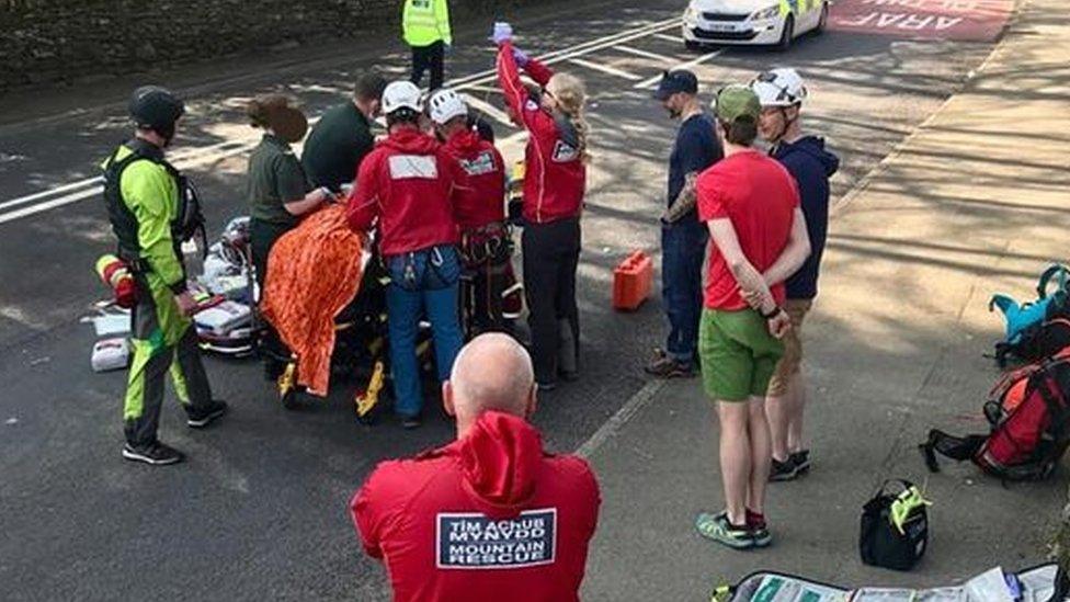 rescuers treating man on road