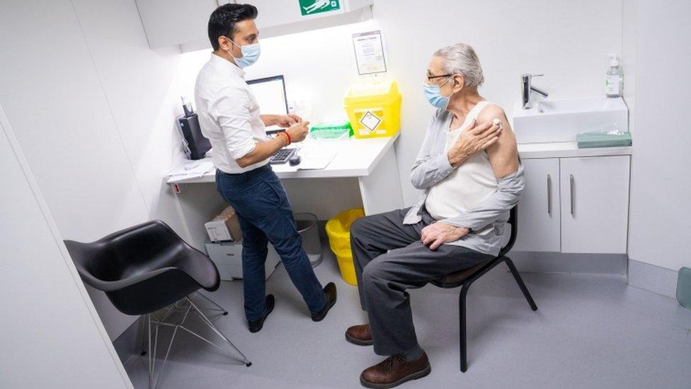 Pharmacist Bhaveen Patel gives a dose of a Covid vaccine to Brian Bourne