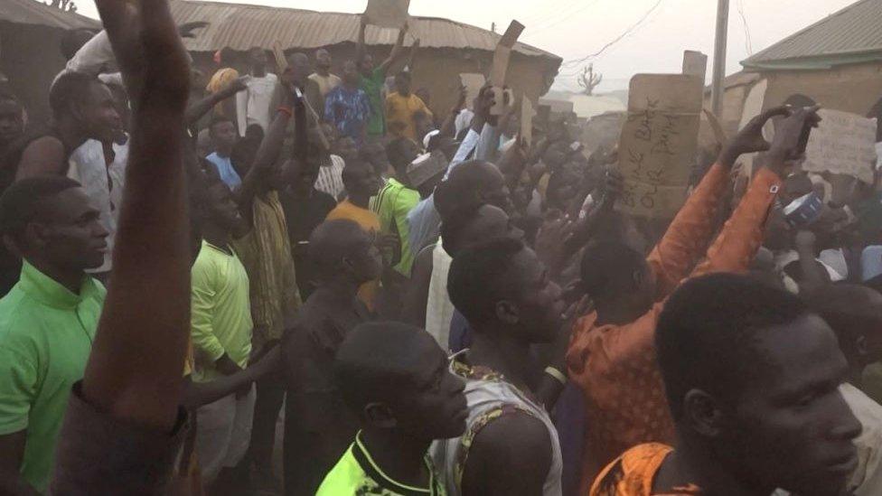 This video grab taken from an AFPTV video on March 7, 2024 shows families of abducted pupils gathering during the visit of the Kaduna State governor Uba Sani after gunmen kidnapped over 280 from a school in Kuriga