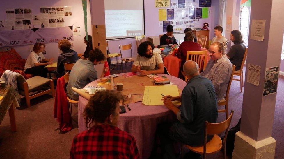 A picture of people sitting around tables at a community centre