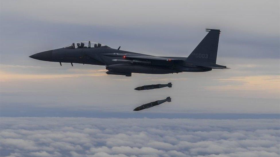 A handout photo made available by the South Korean Defence Ministry shows a South Korean F-15K fighter dropping two JADAM precision bombs during a drill in the sky over South Korea, 04 October 2022.