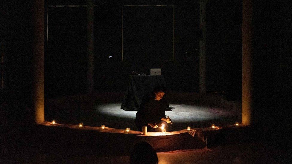 Sinéad O'Neill-Nicholl lighting a candle as part of her live performance