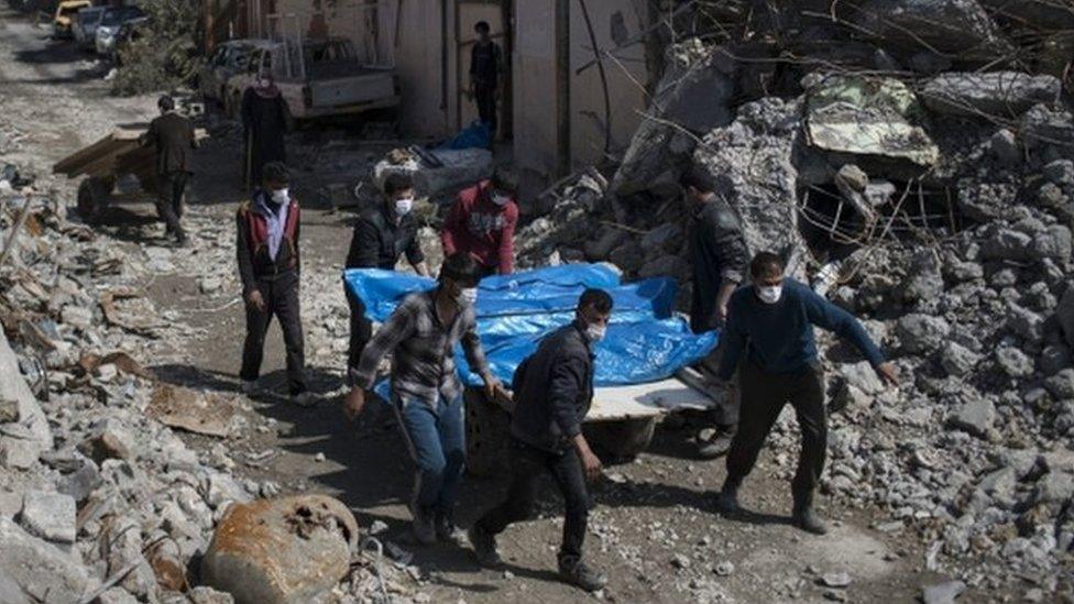 Residents carry the bodies of several people killed during fights between Iraqi security forces and Islamic State on the western side of Mosul, Iraq, on 24 March, 2017.