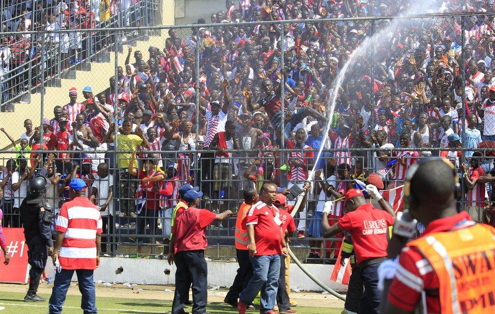 Oficers of national fire brigade spray water on fans to combat the heat before Liberia vs Togo 2017 Africa Cup of Nations qualification match at the Antoinette Tubman Stadium, Monrovia, Liberia 05 June 2016.