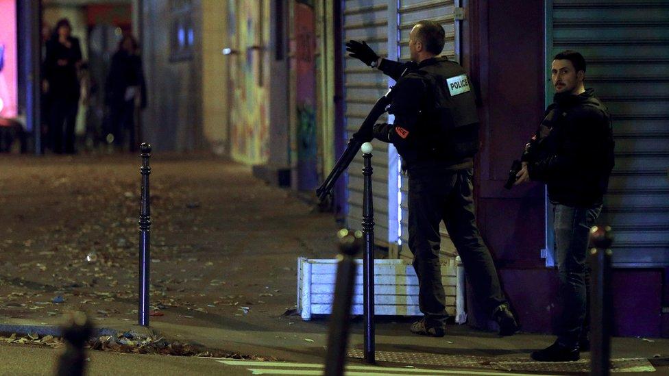 French police officers ask passersby to take cover while on the lookout for the shooters who attacked the restaurant "Le Petit Cambodge" earlier tonight in Paris, France, 13 November 2015.