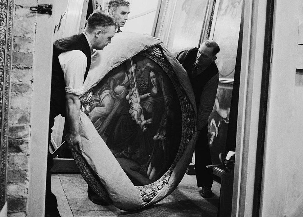 September 1942: Attendants take the painting 'Mother and Child', of the Botticelli school, out of storage for routine inspection in a subterranean chamber at Manod Quarry, north Wales