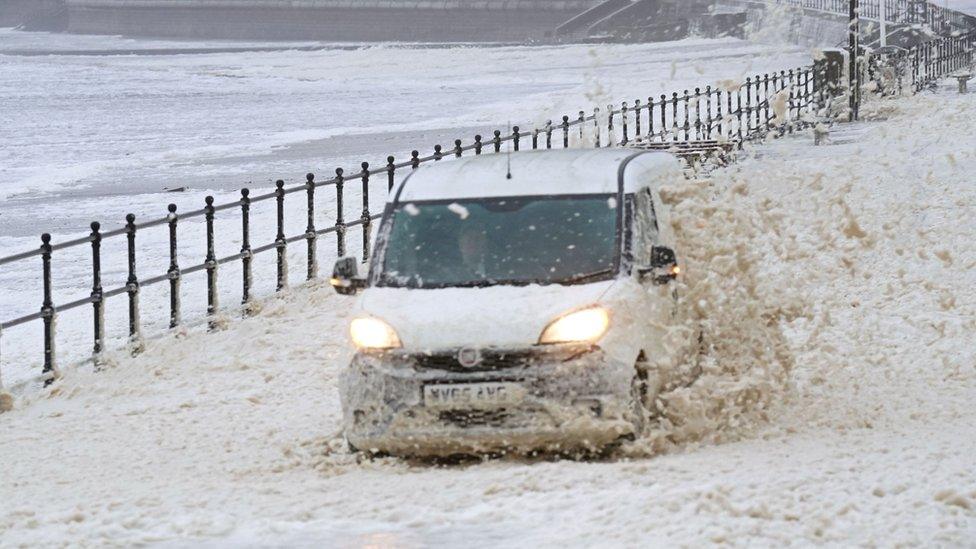 A van drives though the sea foam in Seaburn, Sunderland