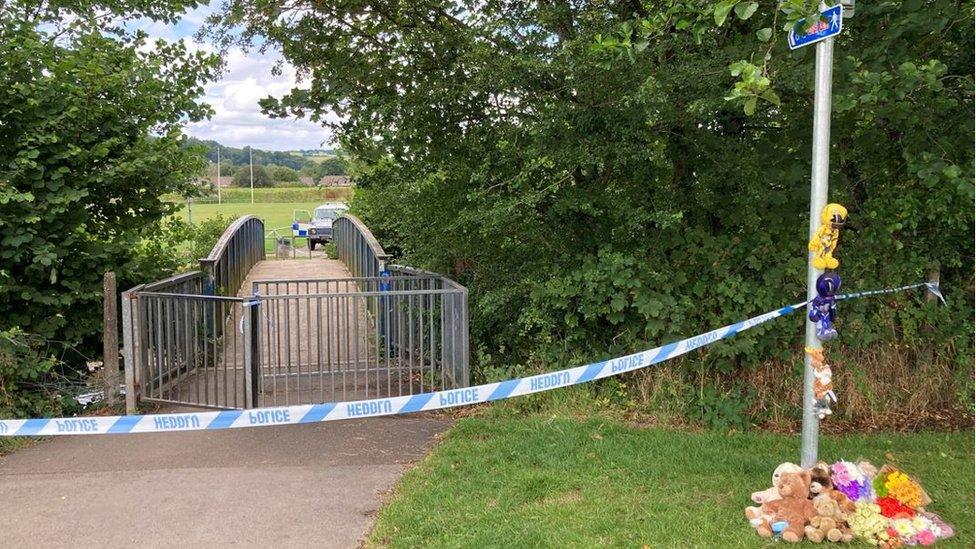 Toys and floral tributes at the scene of a police cordon