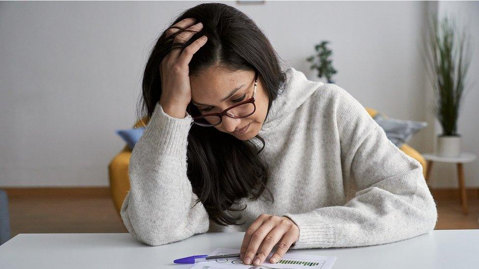 Woman looking at energy bill - stock shot