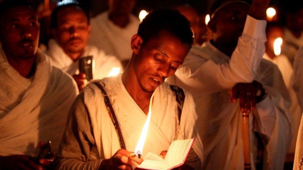 People holding candles and Bibles inside the Medhane-Alem Orthodox Church, Addis Ababa, Ethiopia - Sunday 1 May 2016