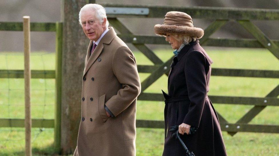 The King and Queen walking together outside the church