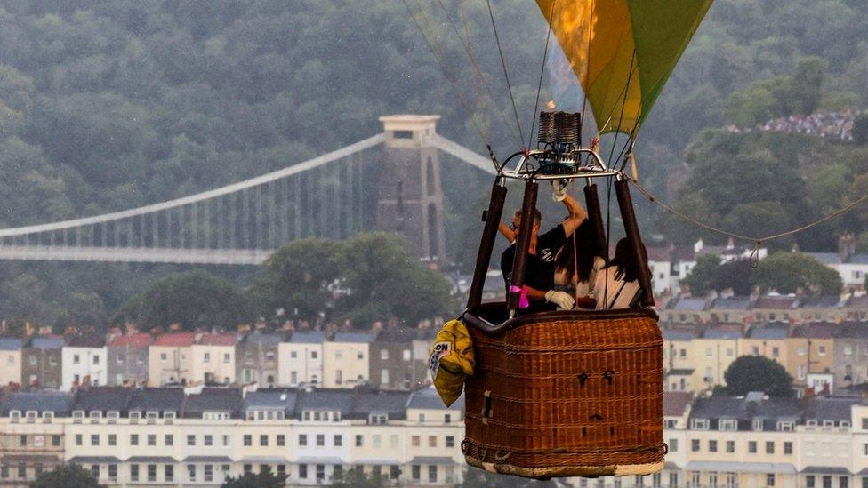 A pilot operates a hot air balloon through the rain during a mass launch at the annual Bristol International Balloon Fiesta